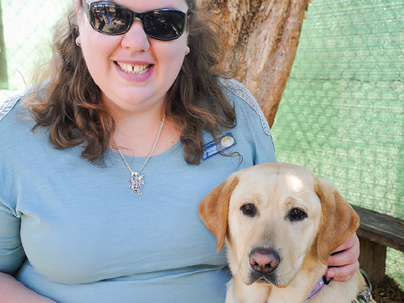 Woman wearing sunglasses and smiling with her dog