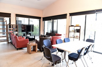 Inside living area with two tables and a TV