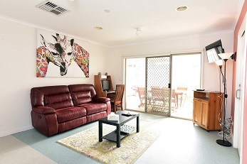 Living room area with couch and balcony sliding doors