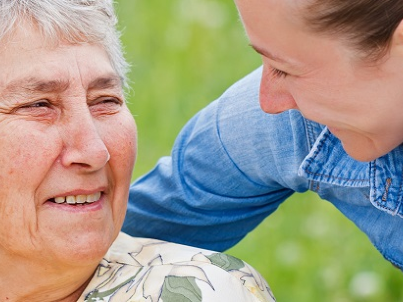 Older woman being supported by a female practitioner