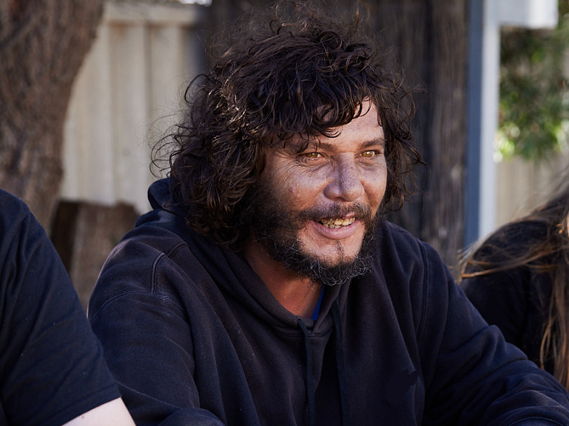 Two men and a woman sitting outside engaging in conversation