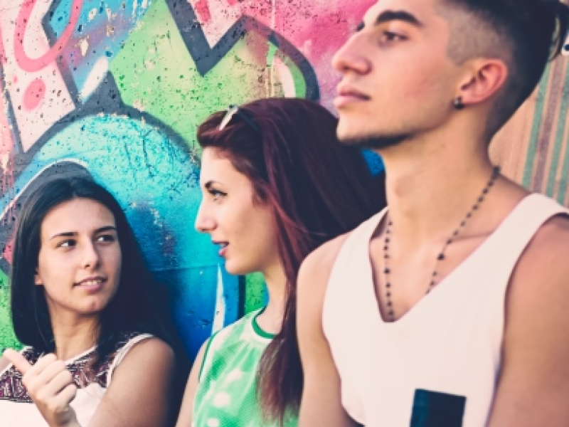 Teens sitting against a wall