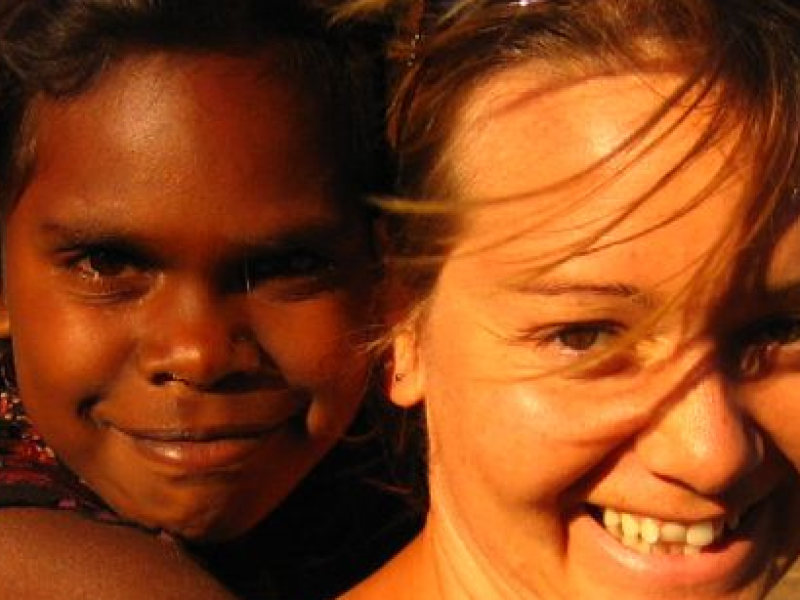 a young girl being carried by a woman, both smiling