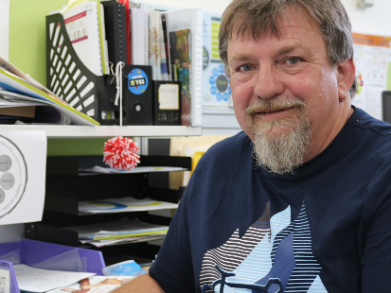 Derek at his desk smiling