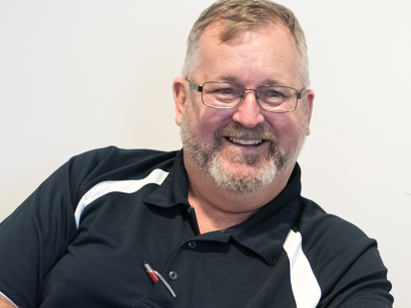 man sitting down and smiling at another man