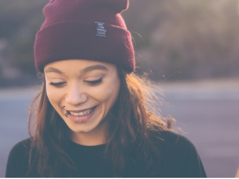 young person smiling and looking down