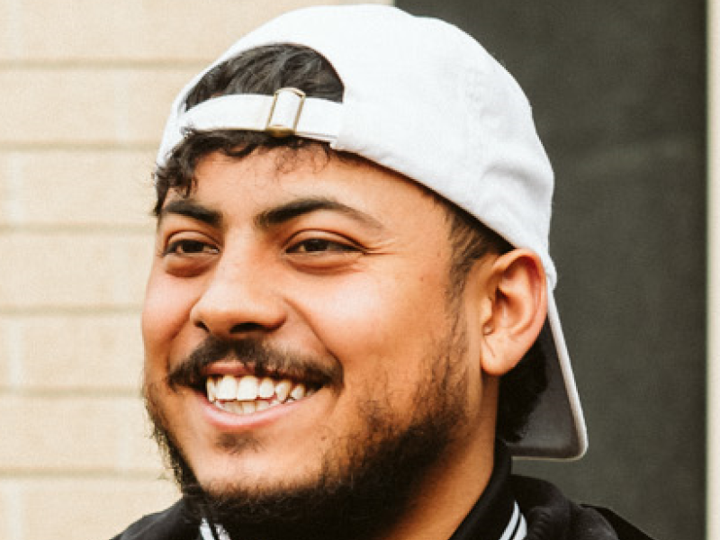 Man smiling with hat on backwards