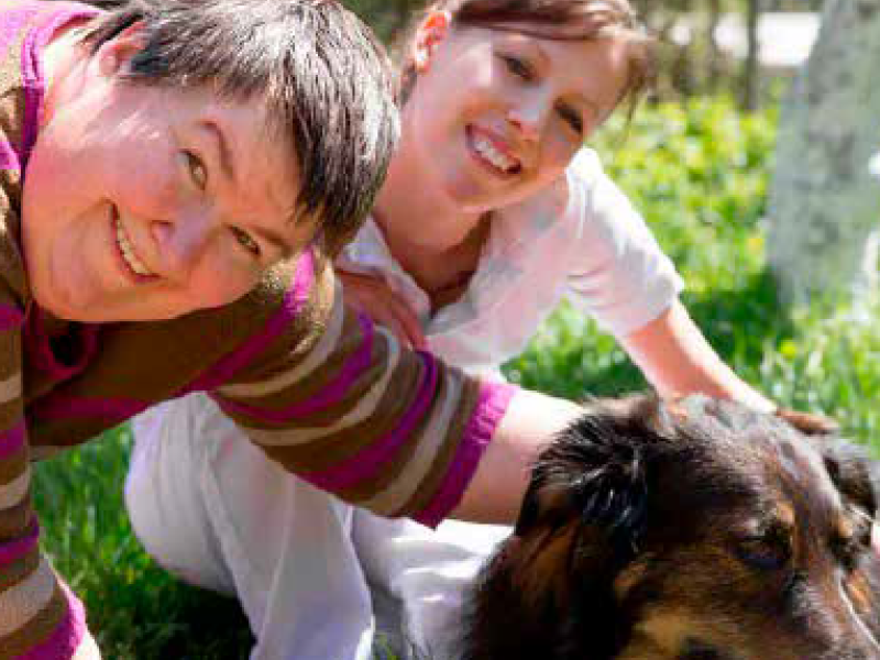 Two women patting a dog