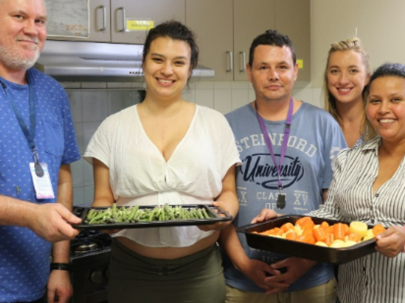 Five people holding trays of food