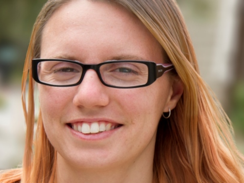 woman wearing glasses holding text books