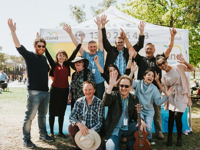 A group of people smiling and holding their arms in the air