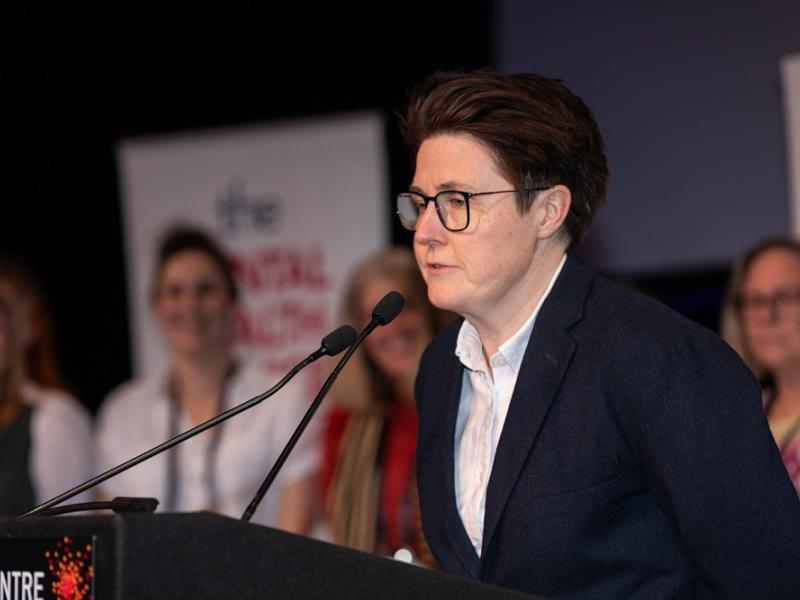 Katie speaking at a lectern