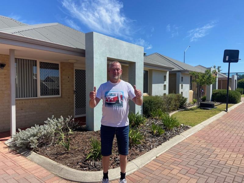 Man standing in front of house with two thumbs up