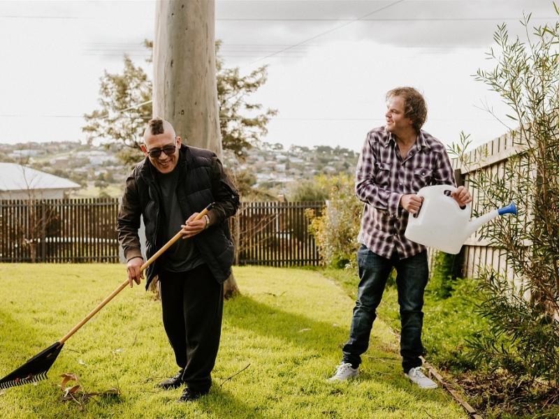 Two men happily gardening outside