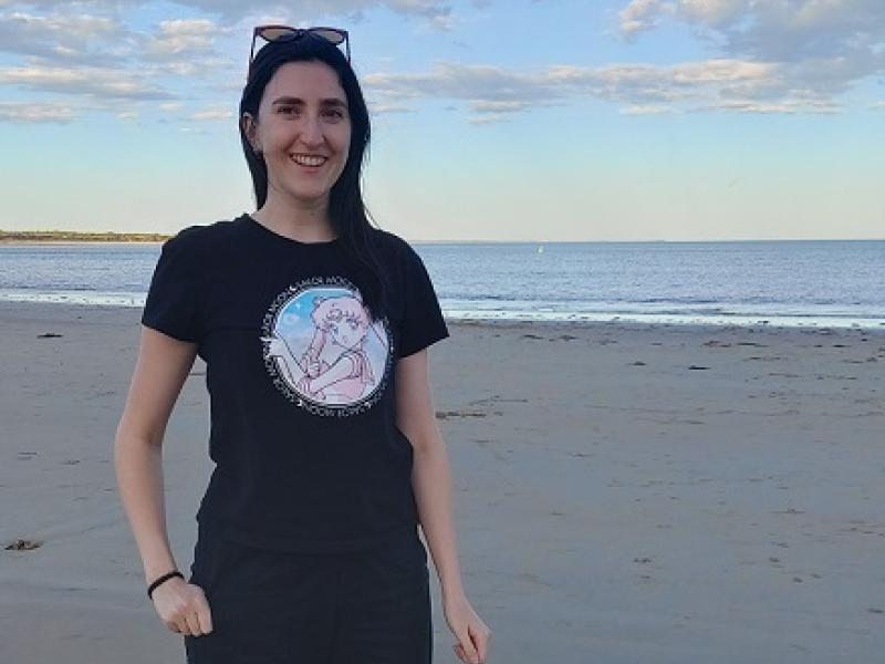 Becky standing on the sand at the beach at sunrise