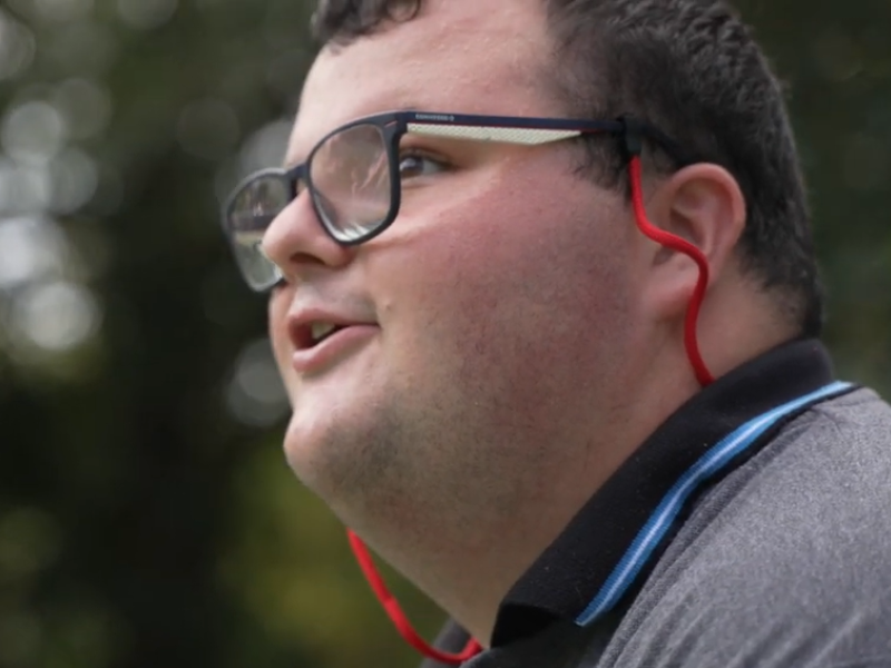Man wearing glasses looking up into the sky