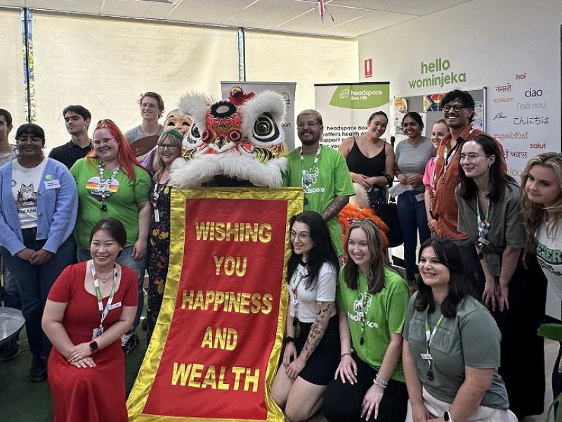 A group of people standing with a Chinese dragon 