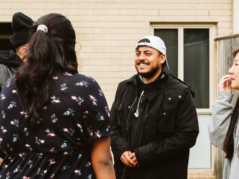 Man smiling with hat on backwards