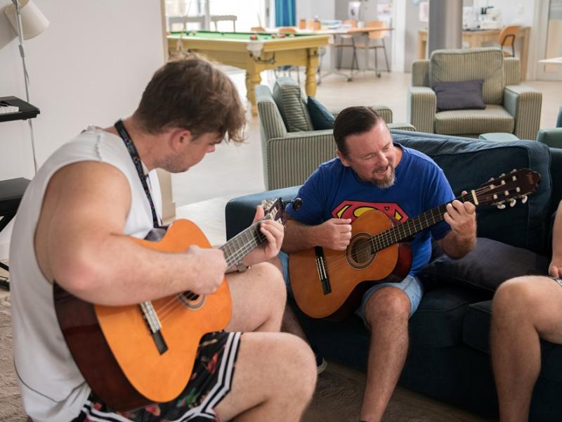 Two men playing the guitar