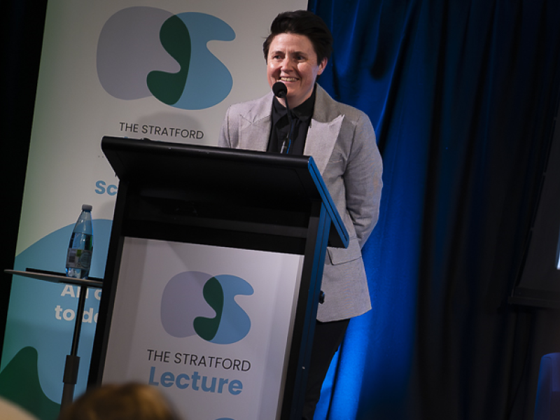 A woman speaking at a Lectern 