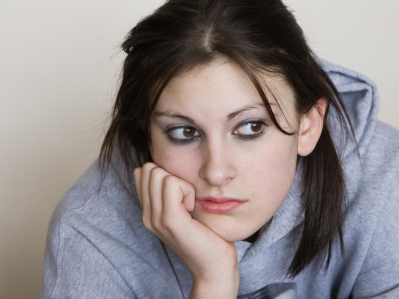 Young woman holding chin with hand sadly