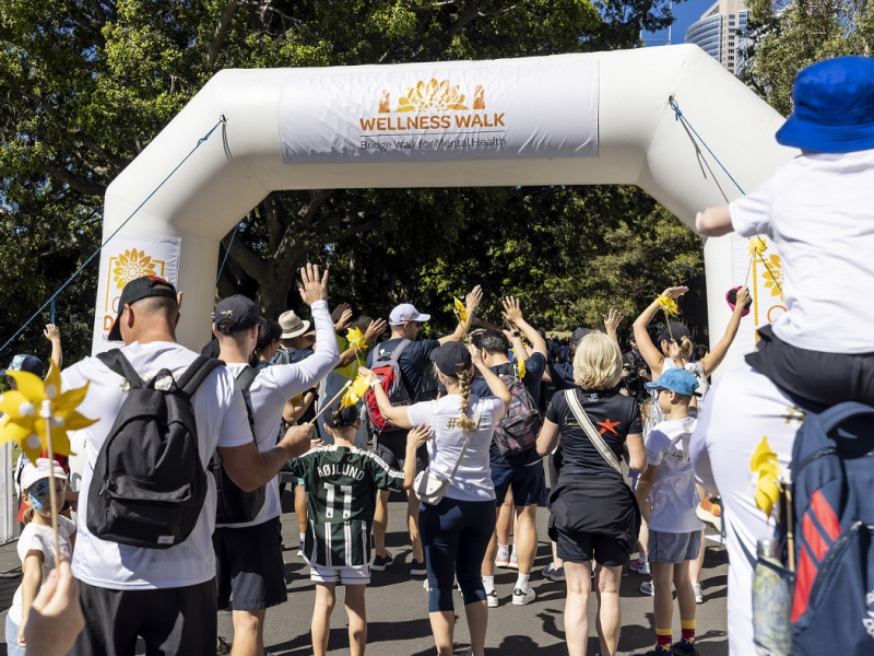 People walking to a finish line with hands held up high