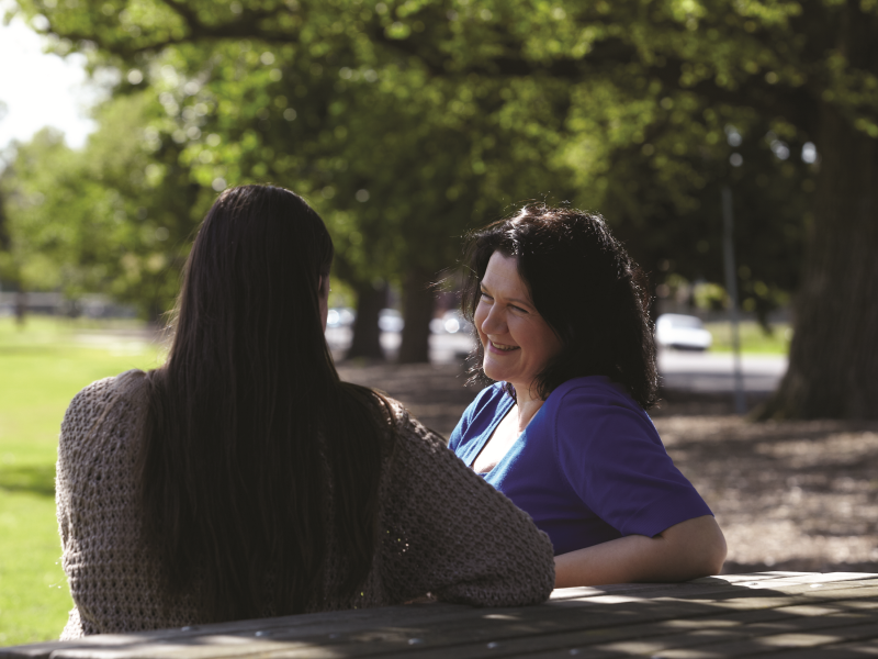 two women chatting in a park
