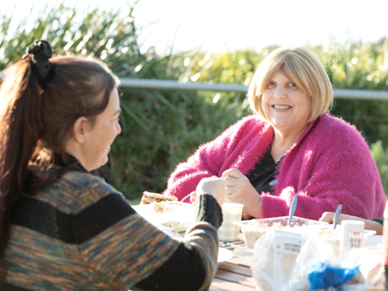 Two women at a picnic table