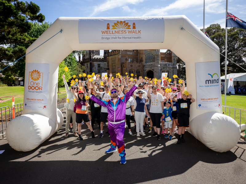The Wellness Walk participants at the start line with arms in the air