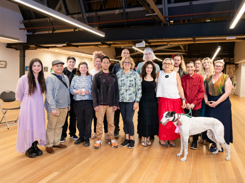 A group of people (with a dog in front) standing for a camera shot