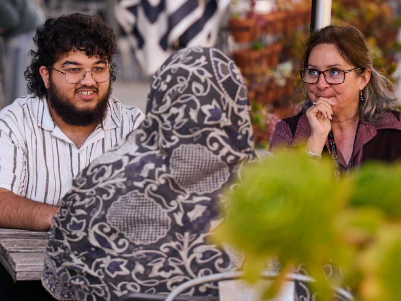 A middle eastern man and woman chatting at a table