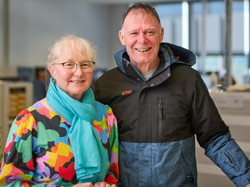 A woman and man standing and smiling inside a home