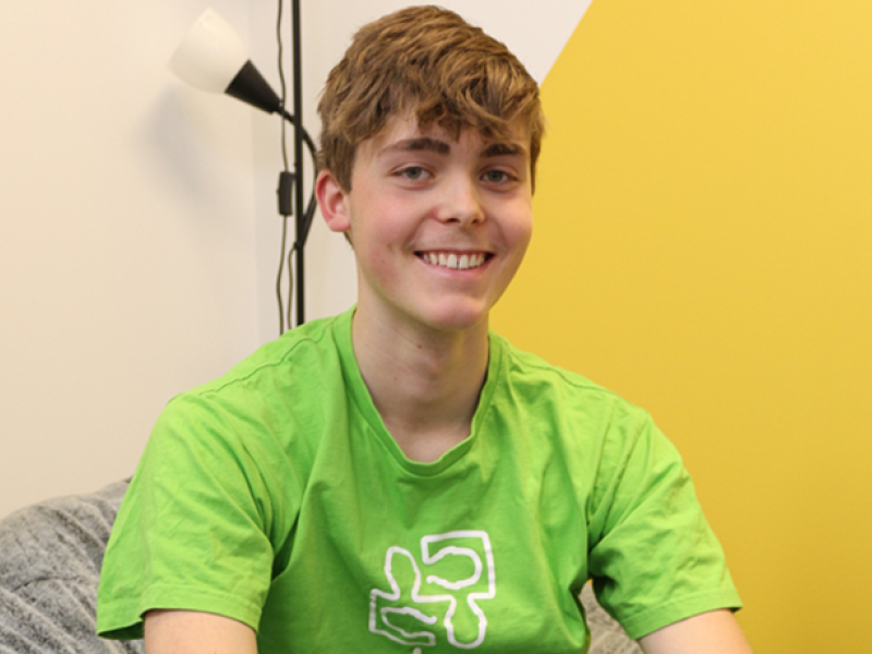 Rohan smiling on a chair wearing a headspace shirt