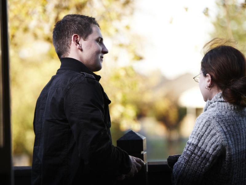 A man and woman chatting near a window