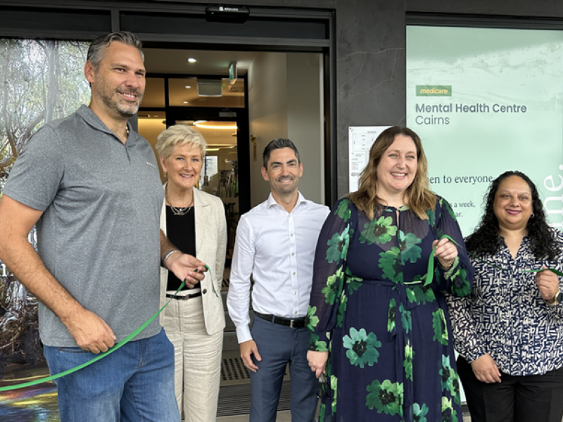 Five people standing and smiling