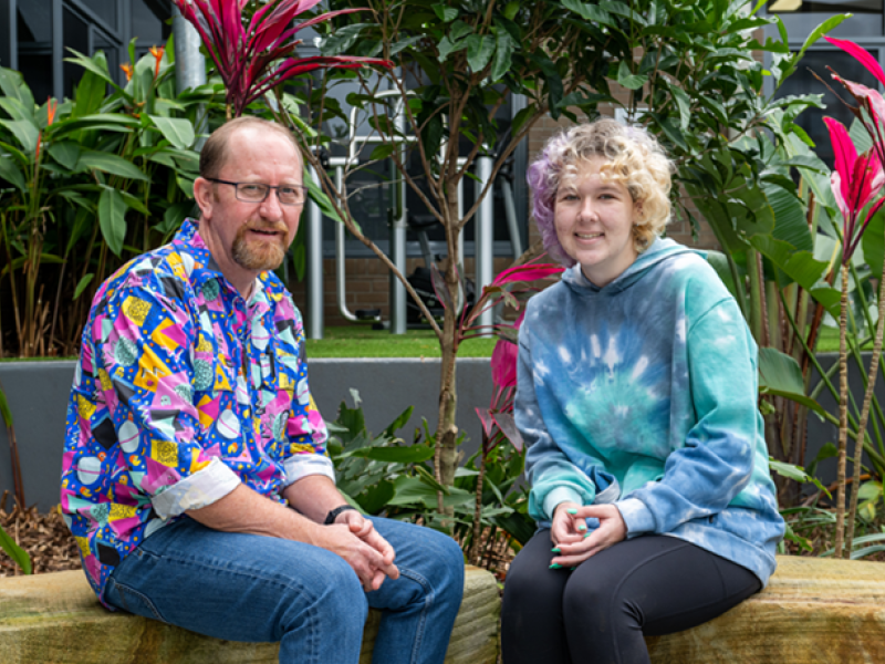 Two people sitting outside chatting in a garden