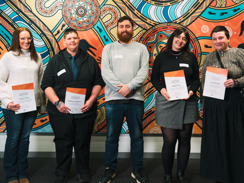 Five people holding certificates