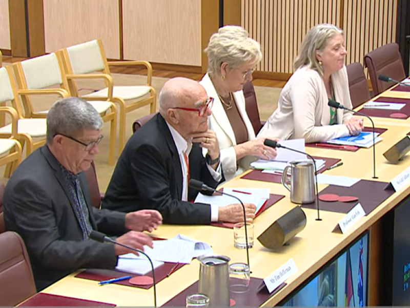 Four people at a table at a hearing
