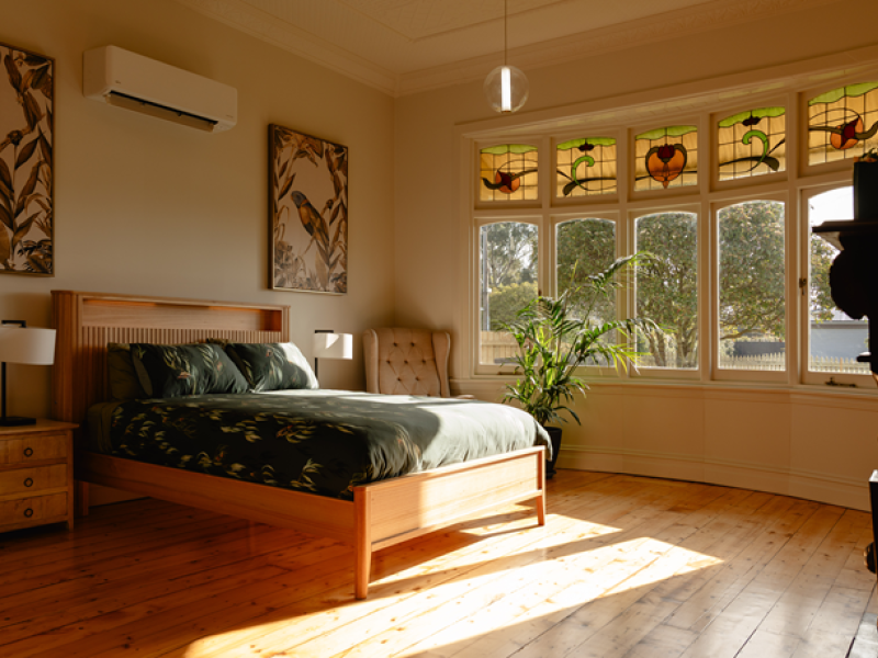 A well lit bedroom with hardwood floors
