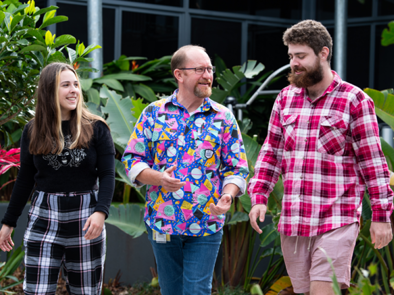 Three people walking in a garden
