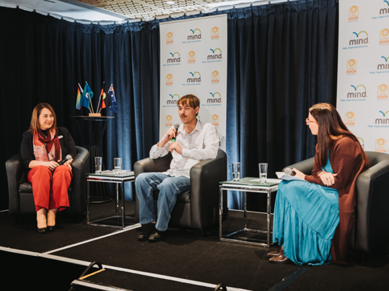 Three people on stage at the Symposium