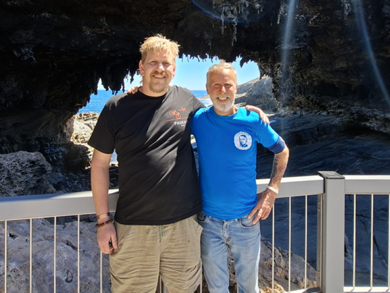 Two men standing outside with arms around each other