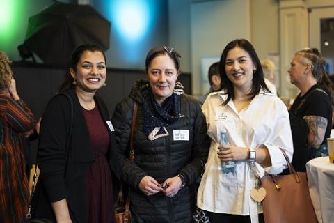 Three women standing and smiling