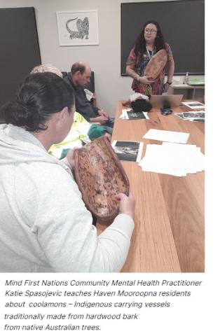 Artwork on bark held up by teacher and student