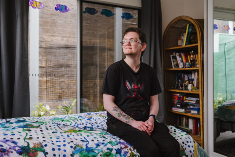 A person looking up and sitting on a bed